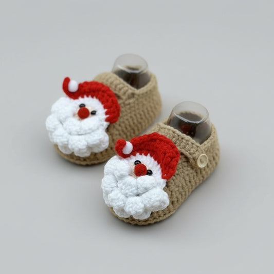 Handmade crocheted baby booties with Santa Claus faces, tan with red and white details