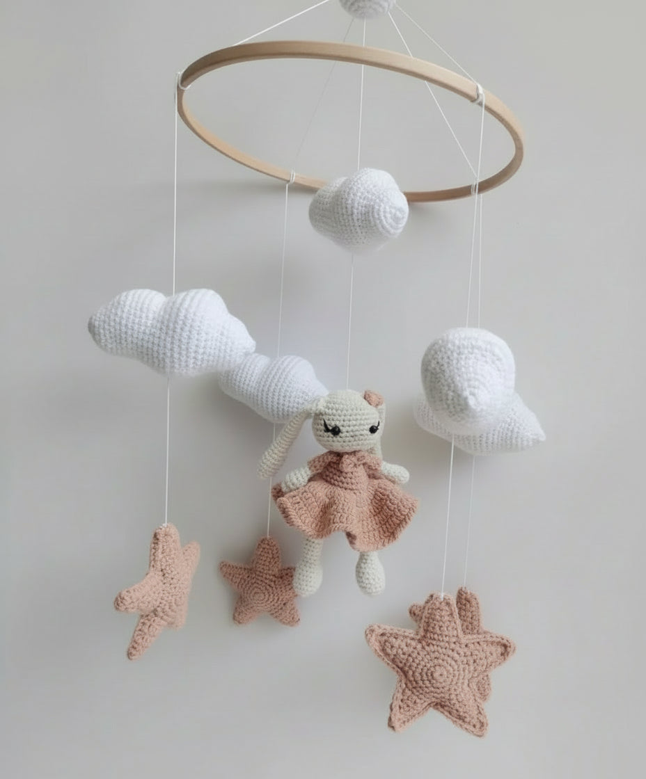 Crocheted baby mobile with bunny, stars, and clouds hanging from wooden ring