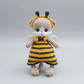 Crocheted stuffed animal in bee costume with yellow and black stripes, white wings