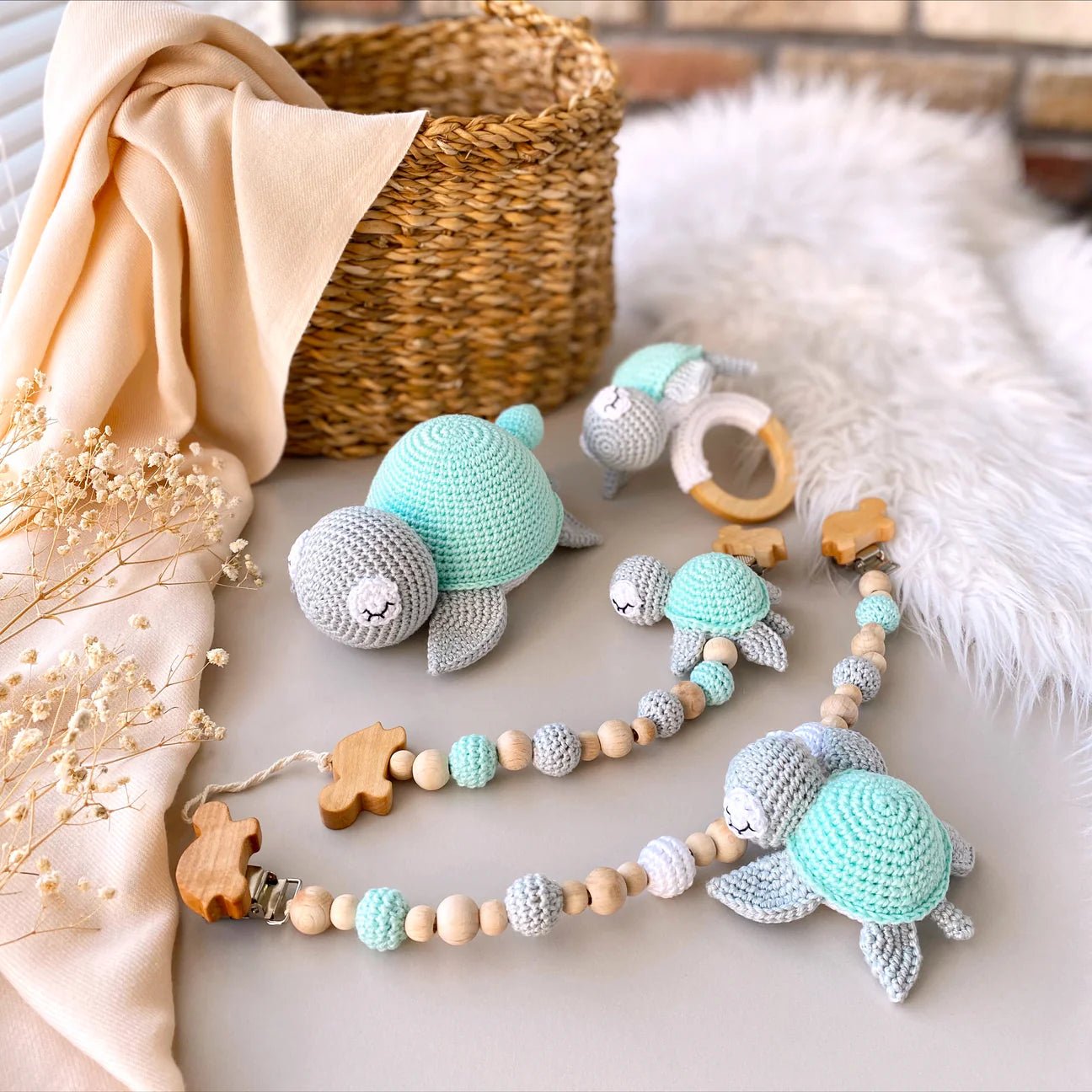 Crocheted turtle toys in mint and gray with wooden teething ring and beaded toy strap