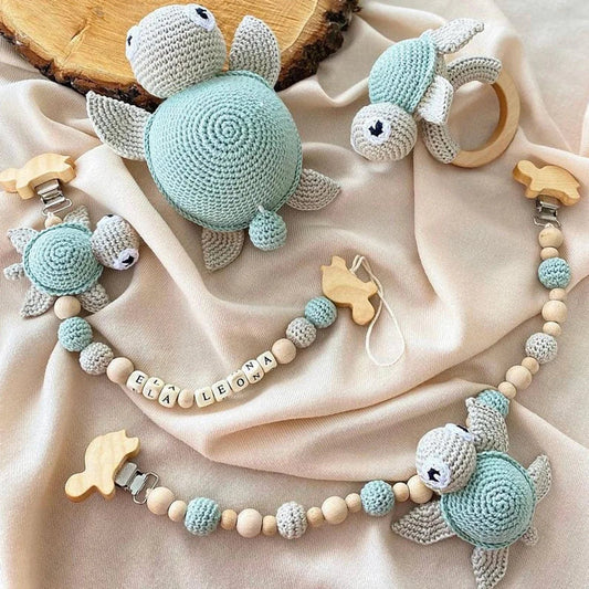 Crocheted sea turtle toys and personalized stroller chain in soft blue and gray colors