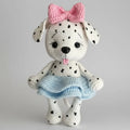 Crocheted dalmatian puppy with pink bow and blue skirt, playful tongue out