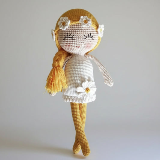 Crocheted doll with yellow hair, braided ponytail, and white daisy dress and accessories