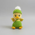 Crocheted baby duck in green outfit with white pom-pom hat, sitting cutely