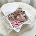 Crocheted pink elephant toys in gift box with gold heart-dotted tissue paper
