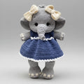 Crocheted elephant stuffed animal wearing blue dress and cream bows