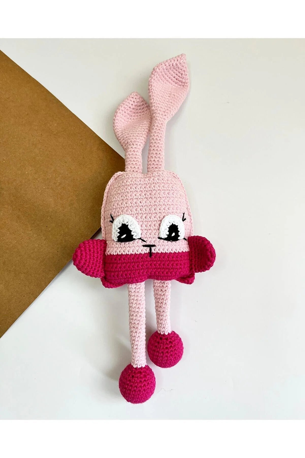 Pink crochet bunny with cute eyes and magenta color-blocked body and feet