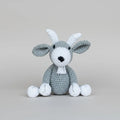 Crocheted gray and white bunny with long ears sitting against a neutral background