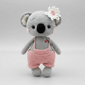 Crocheted koala stuffed animal in gray and pink with white flower