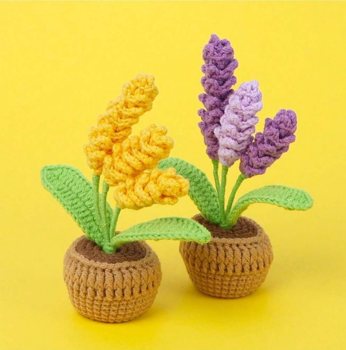 Two crocheted potted flowers: yellow and purple blooms with green leaves on yellow background