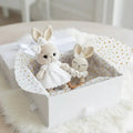 Two crocheted bunnies in white dress and sleepwear inside a polka-dot gift box