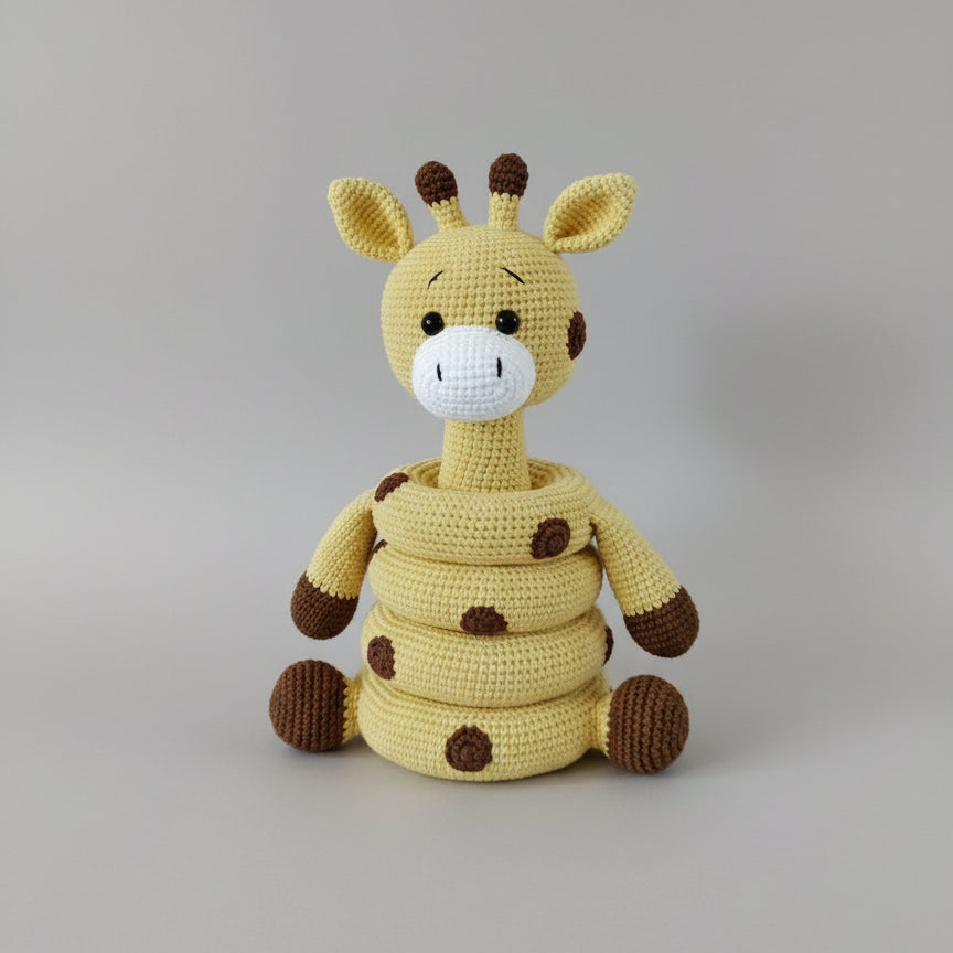 Crocheted yellow giraffe stuffed animal with brown spots, sitting on wooden surface