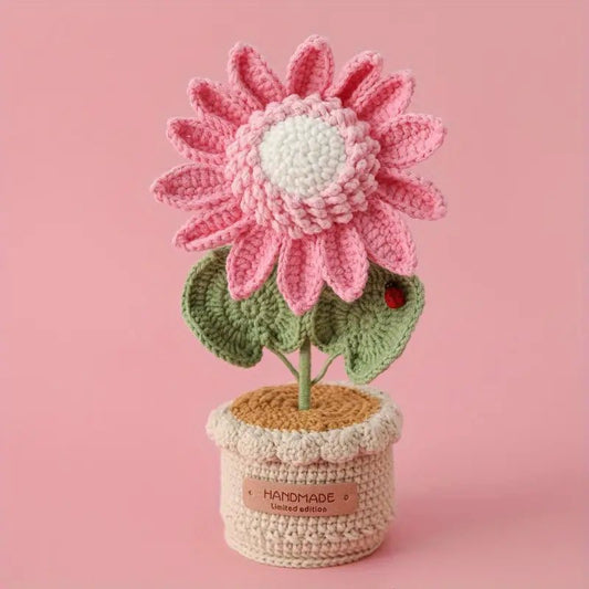 Crocheted pink flower with green leaves in a handmade limited edition pot