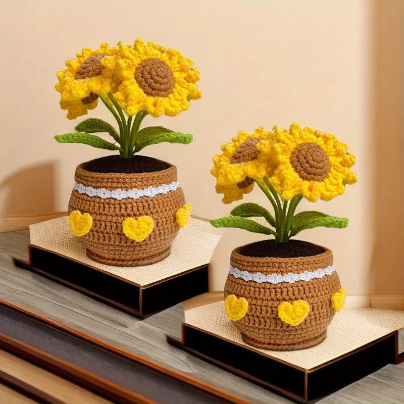 Crocheted sunflowers in brown pots with yellow hearts, sitting on display shelves.