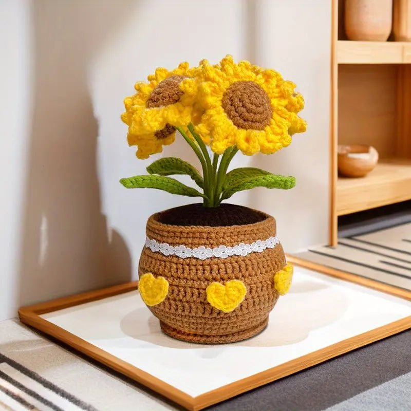 Crocheted sunflowers in brown heart-decorated pot on white framed surface