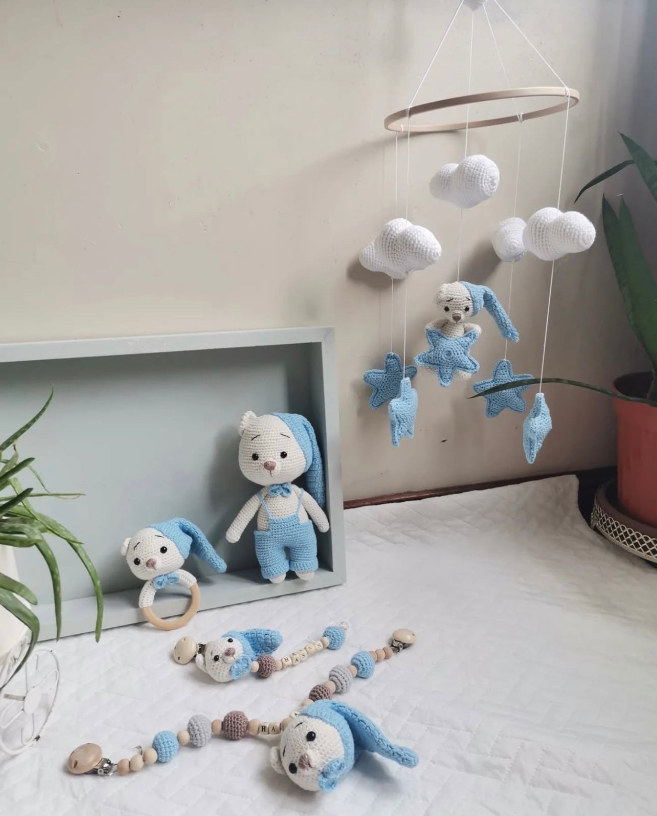 Handmade blue and white crochet baby mobile with clouds, stars, and stuffed bunny toys