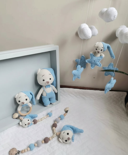 Crocheted blue and white baby toys: bunnies, cloud mobile, star garland, and wooden teething rings