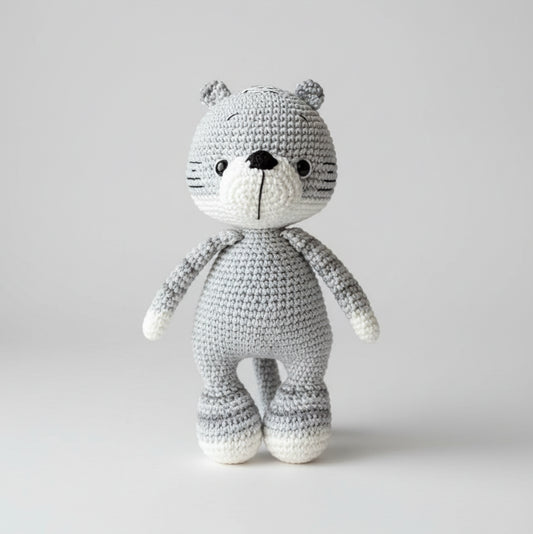 Gray and white crocheted teddy bear with button eyes standing upright