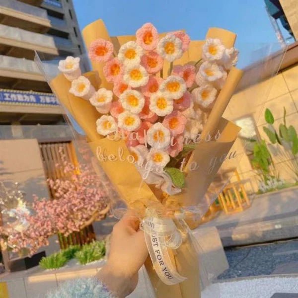 Pastel flower bouquet with white and pink blossoms wrapped in yellow paper, tied with a bow