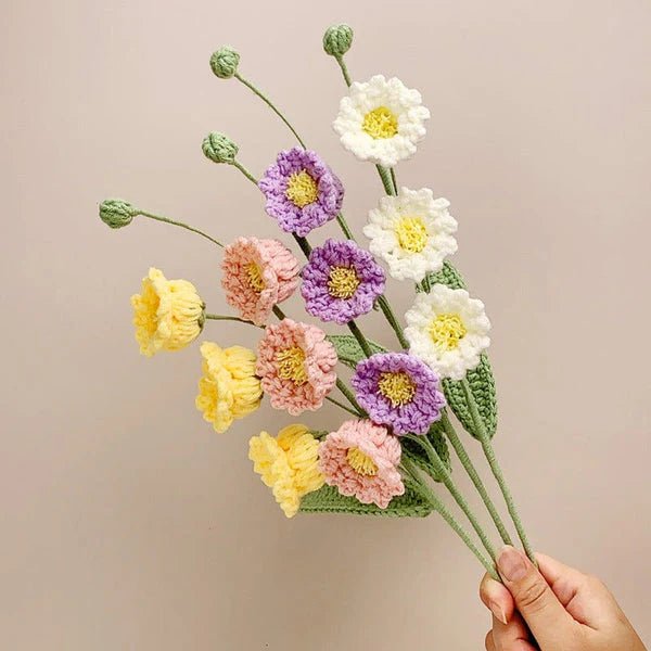 Crocheted bouquet of yellow, white, pink, and purple flowers with green stems