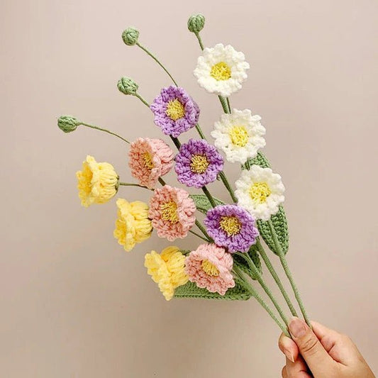 Crocheted bouquet of yellow, white, pink, and purple flowers with green stems