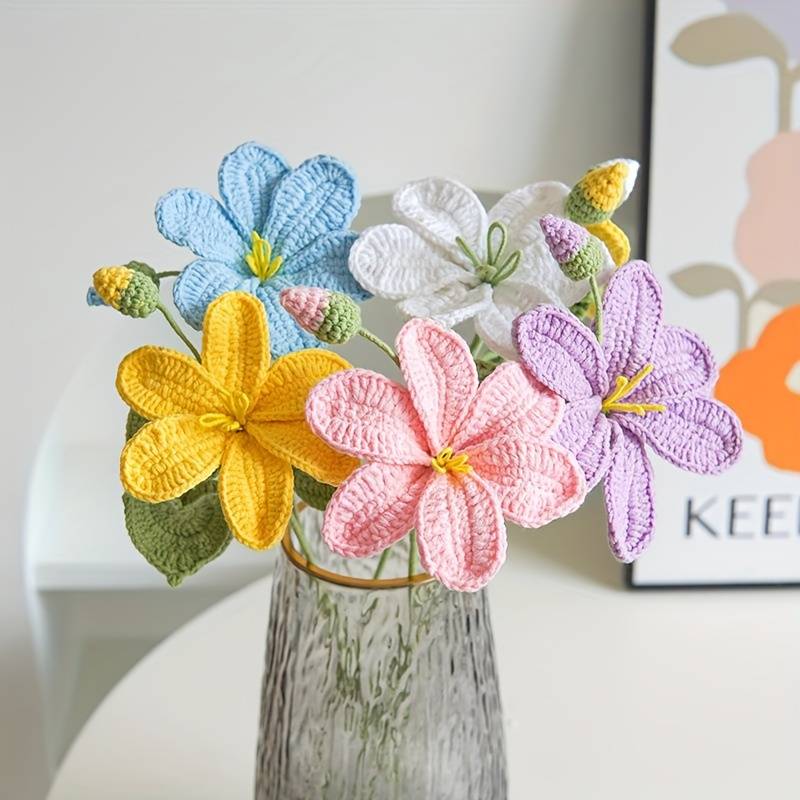 Colorful crocheted flowers in pastel shades arranged in a textured glass vase