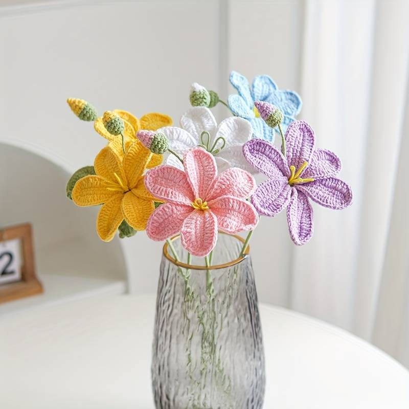 Crocheted flowers in yellow, pink, purple, and blue in a textured glass vase