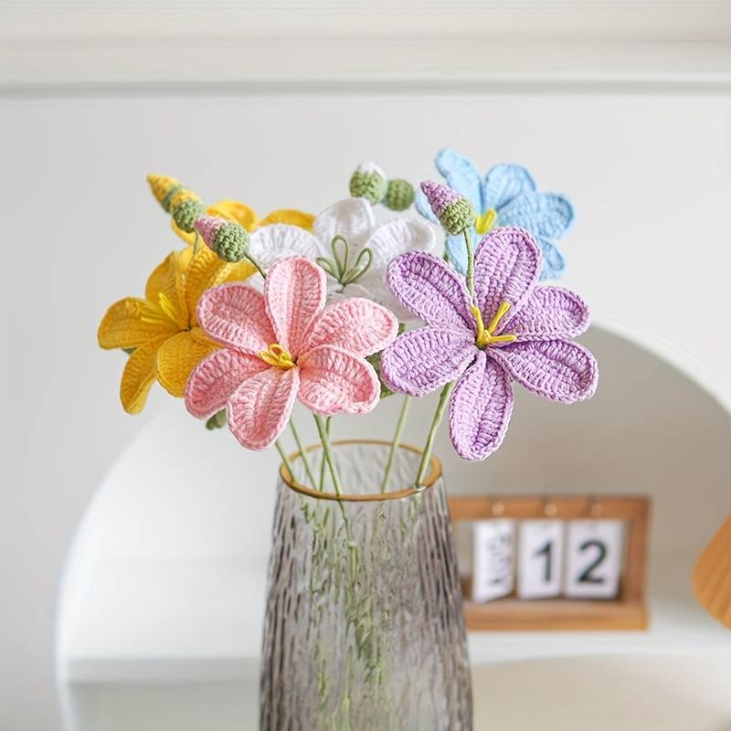 Crocheted colorful flowers in pastel yellow, pink, purple, and blue in a textured vase