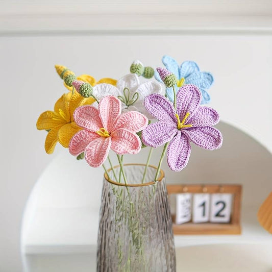 Crocheted colorful flowers in pastel yellow, pink, purple, and blue in a textured vase