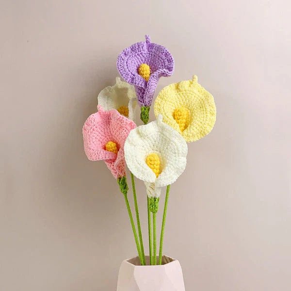 Crocheted calla lilies in purple, pink, yellow, and white in a geometric vase