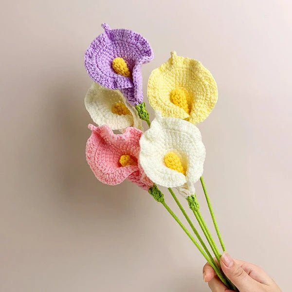 Crocheted calla lilies in purple, yellow, pink, and white, held by a hand