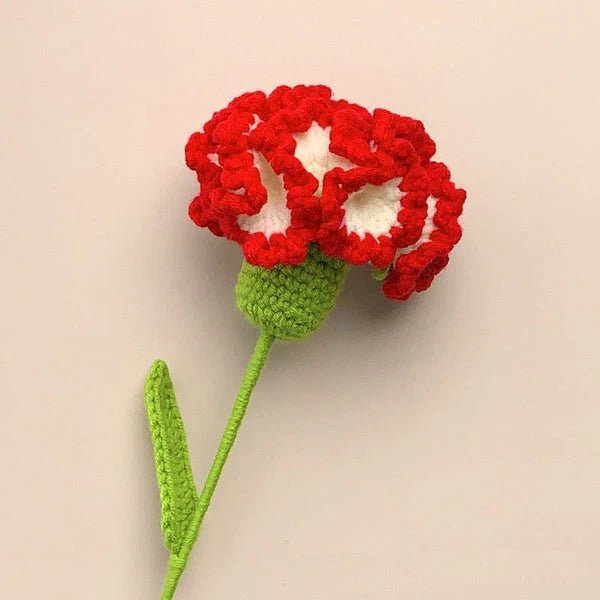 Crocheted red flower with green stem and leaf against neutral background