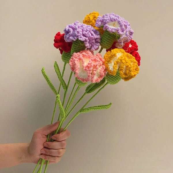 Crocheted bouquet of colorful flowers with green stems held in a hand