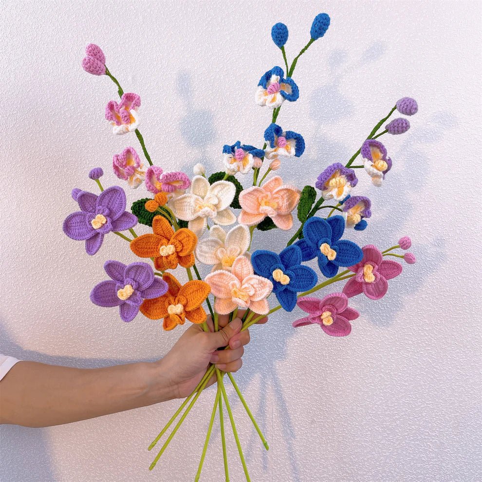 Colorful crocheted orchid bouquet held by a hand against a textured background