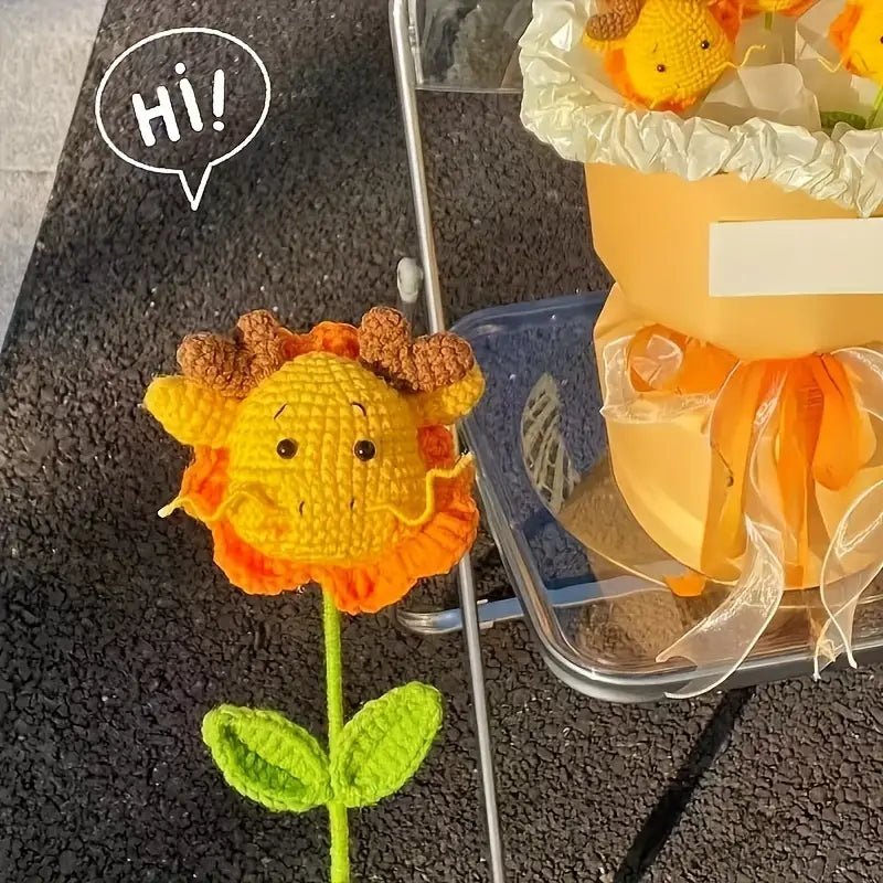 Crocheted sunflower with cartoon face saying "Hi!" next to gift-wrapped flowers