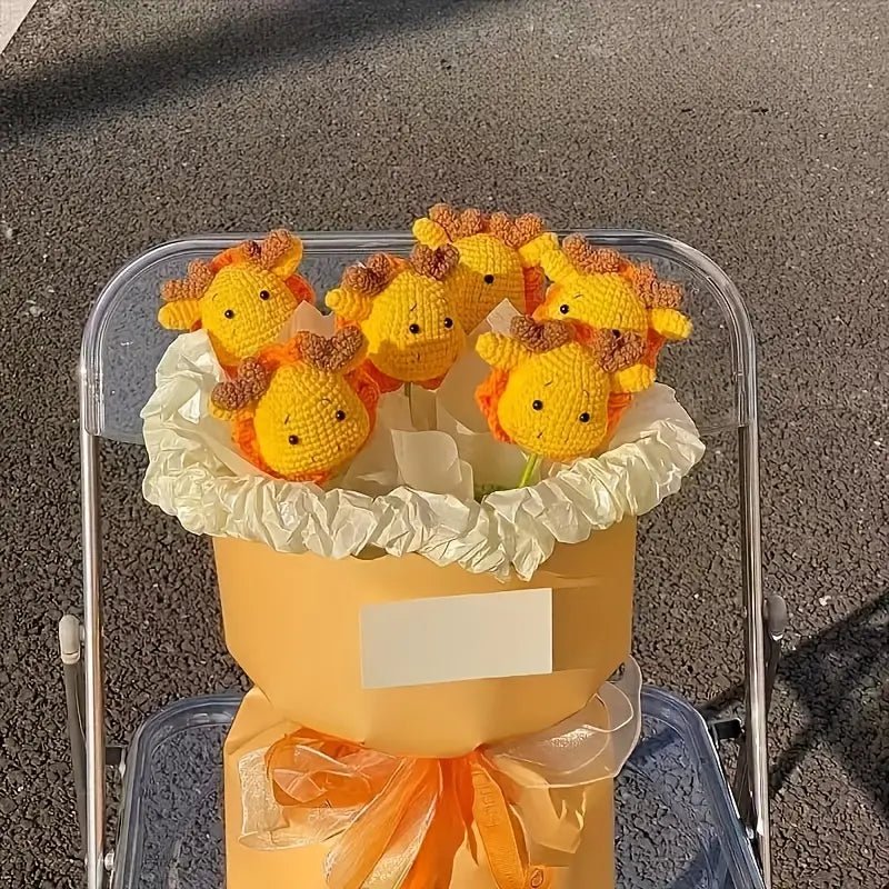 Knitted yellow chicks in a wrapped bouquet with orange ribbon and tissue paper
