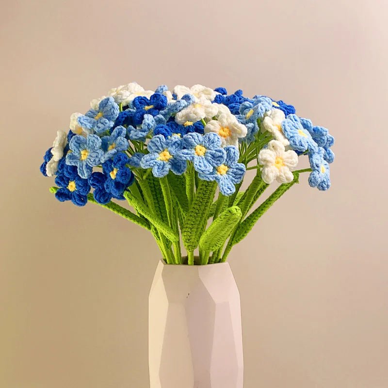 Crocheted bouquet of blue and white forget-me-not flowers in a geometric white vase