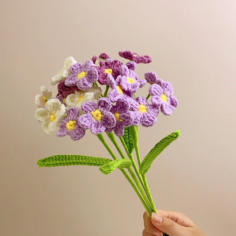 Crocheted bouquet of purple and white flowers with yellow centers
