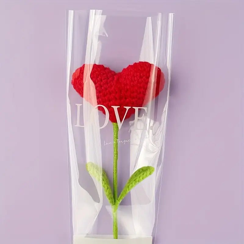 Red knitted heart flower in clear packaging with 'LOVE' text