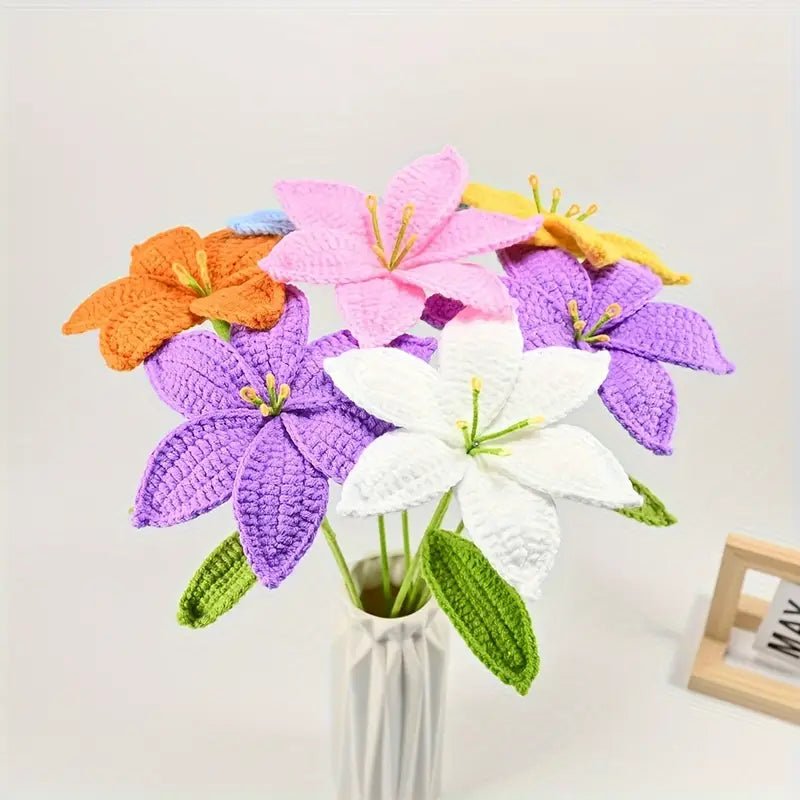 Crocheted lilies in purple, pink, orange, white, and yellow in a white vase