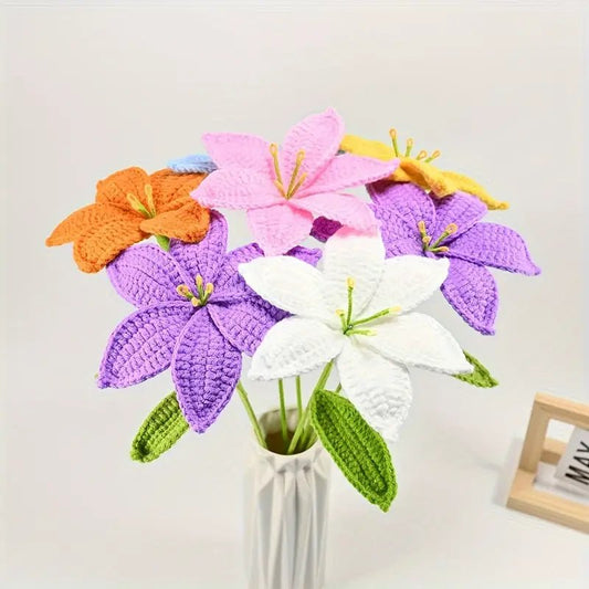 Crocheted lilies in purple, pink, orange, white, and yellow in a white vase