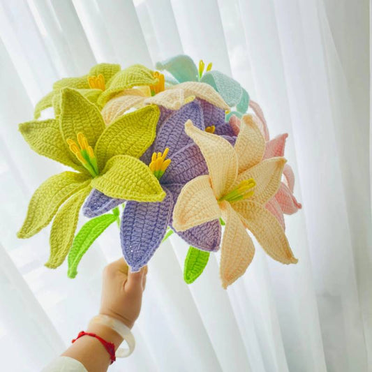 Crocheted colorful lilies in green, purple, yellow, and pink held by a hand