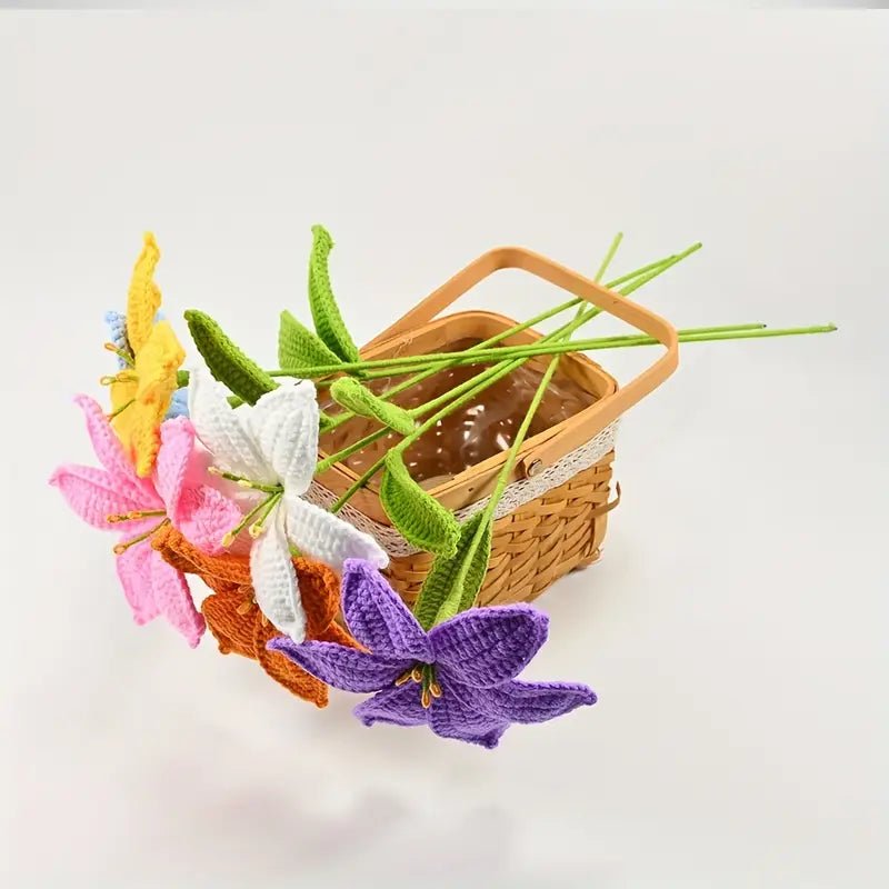 Colorful knitted flowers with green stems beside a woven wooden basket