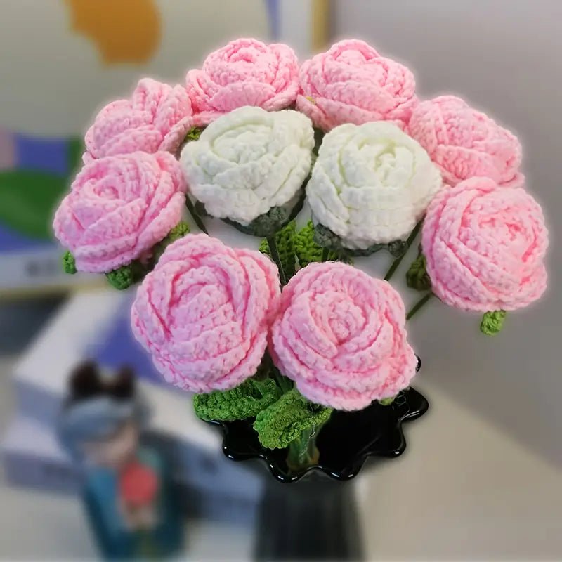 Crocheted bouquet of pink and white roses with green stems in a black vase