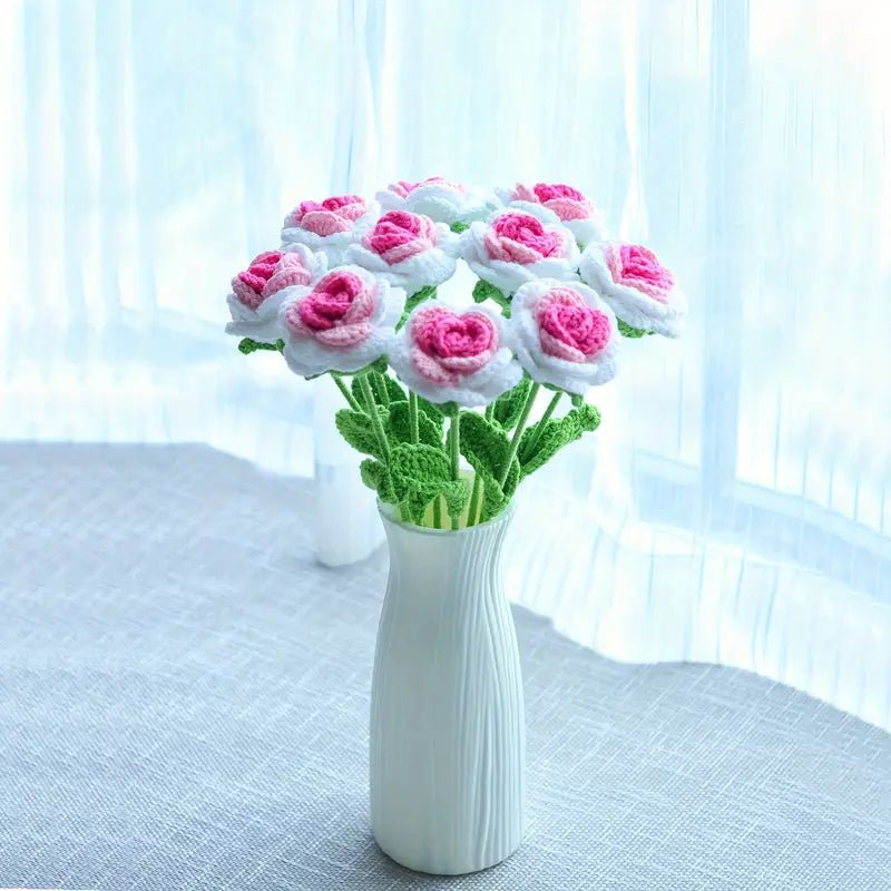 Crocheted pink and white roses in a white textured vase by a soft blue window