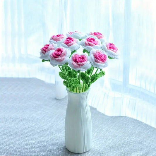 Crocheted pink and white roses in a white textured vase by a soft blue window