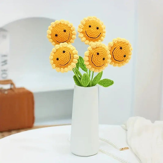 Crocheted smiling sunflowers in white vase with happy yellow faces and green stems