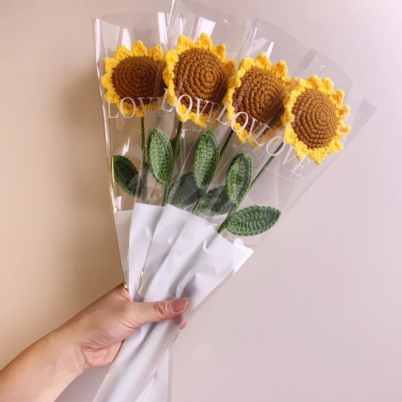 Handmade crocheted sunflowers in clear plastic sleeves with "LOVE" text