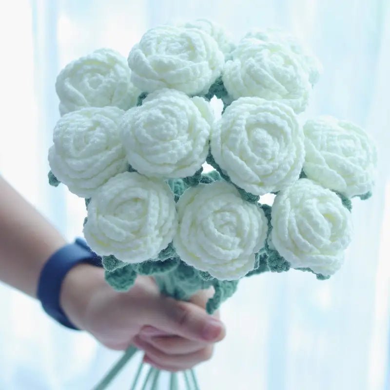 White crocheted roses bouquet held by a hand with blue wristband