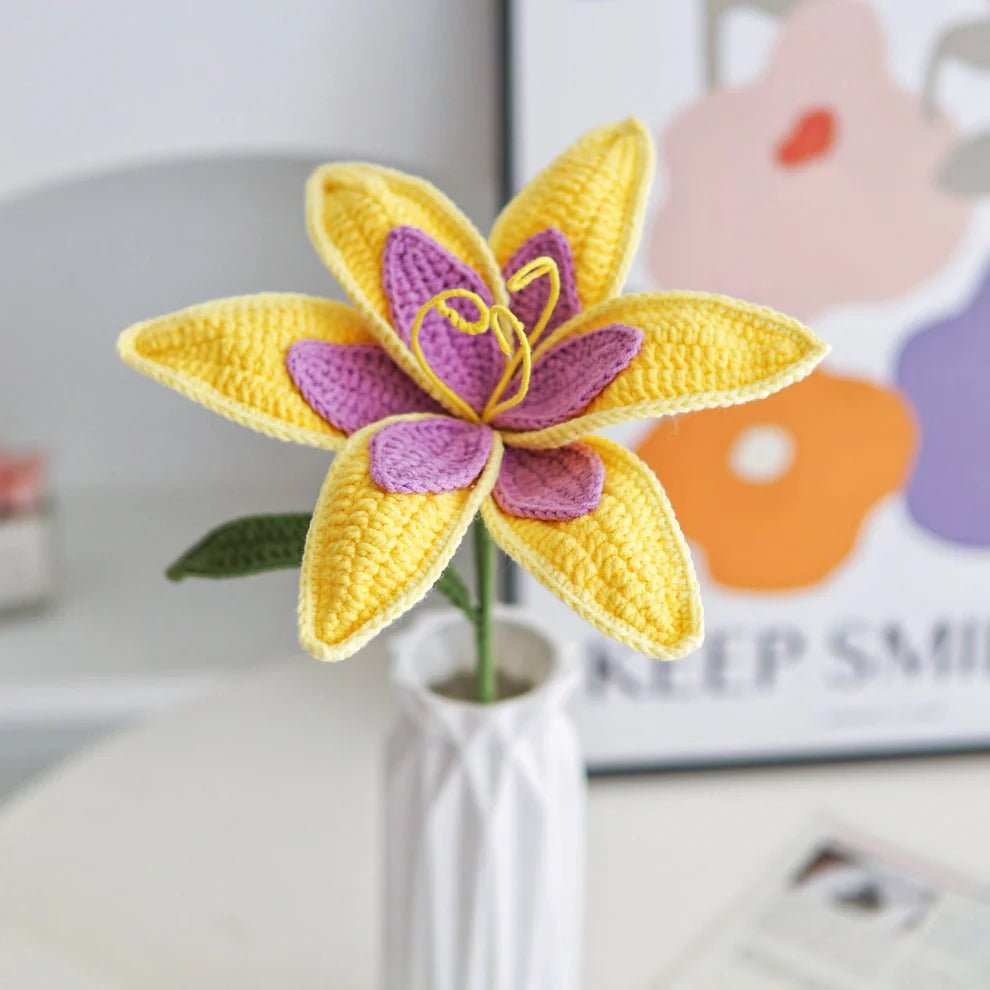 Crocheted yellow and purple flower with delicate petals in a white vase